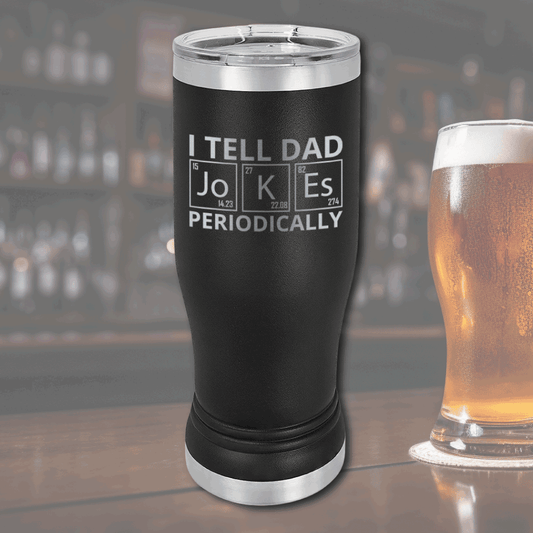 Black stainless steel pilsner tumbler with "I tell dad jokes periodically" text in periodic table style at bar setting